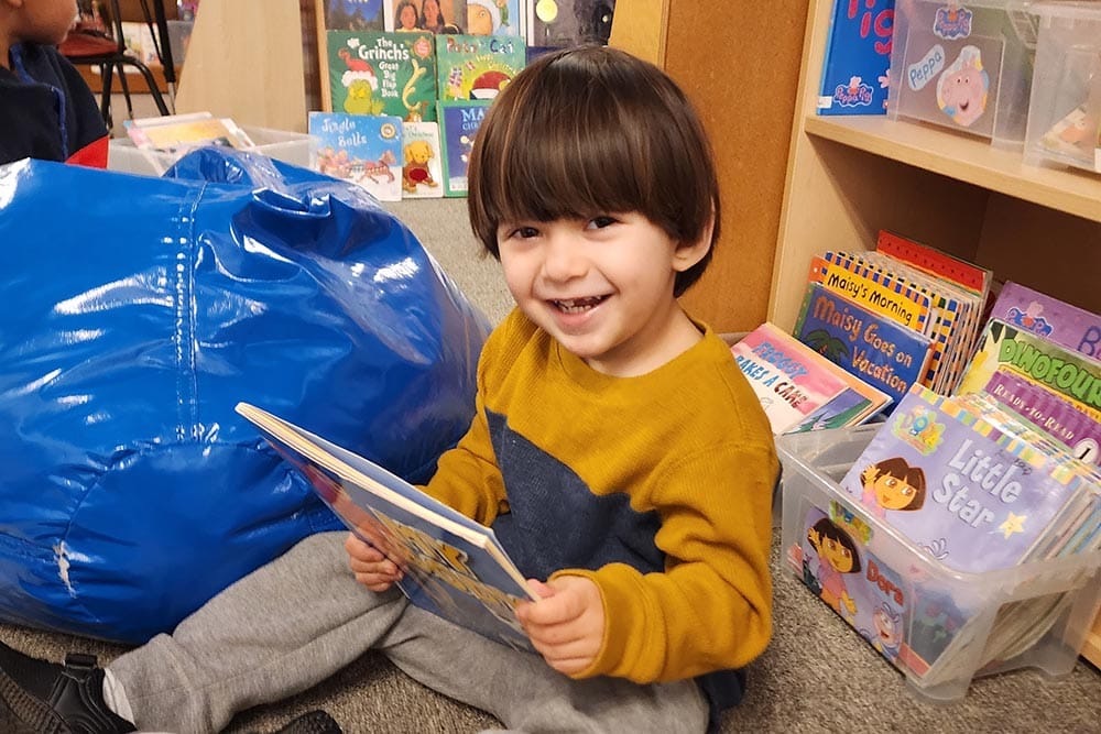 Child Smiling With Books