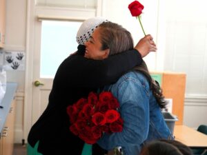 Alexandra Hilario, Executive Director, Gives A Hug And Valentine's Rose To Day Home Staff.